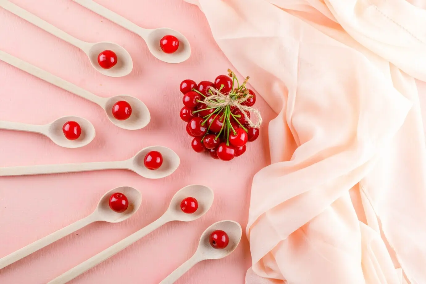 Draufsicht auf Kirschen in Holzlöffeln